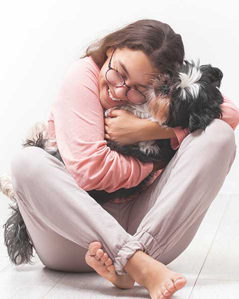Mujer joven abrazando a un perro